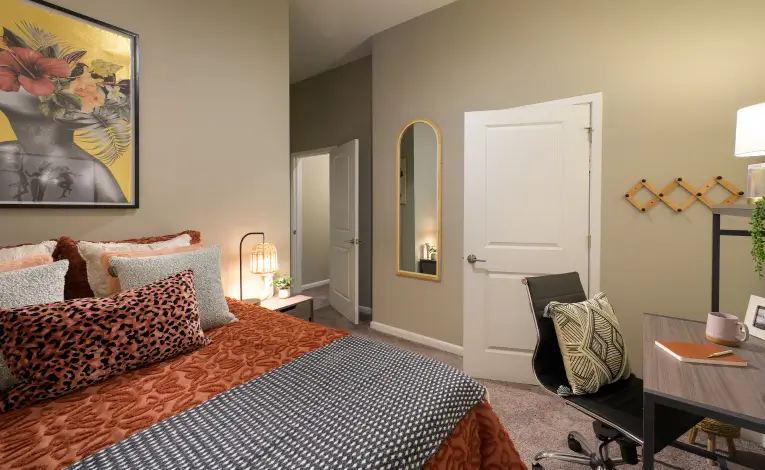 a furnished student apartment bedroom with a study desk