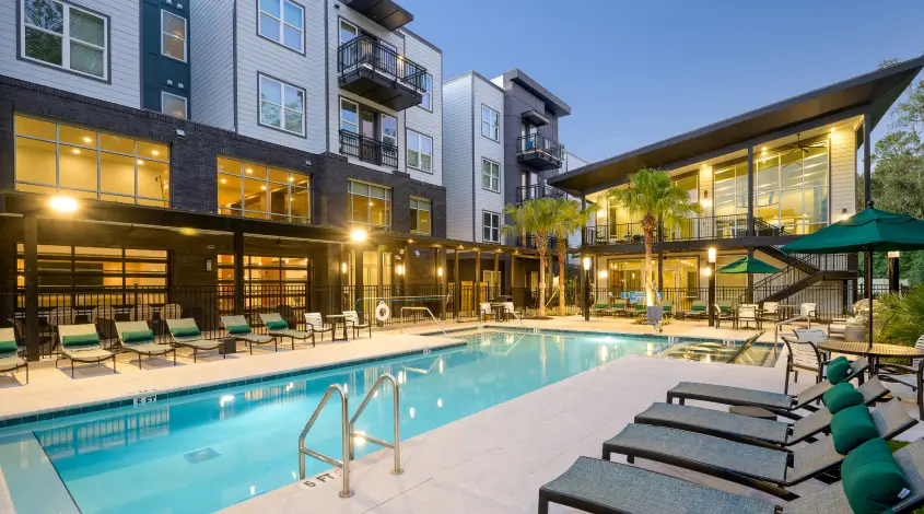 an outdoor pool with poolside lounge seating