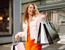 a young woman holding shopping bags outside