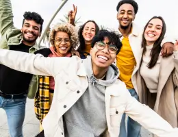 a group of diverse young adults smiling outside
